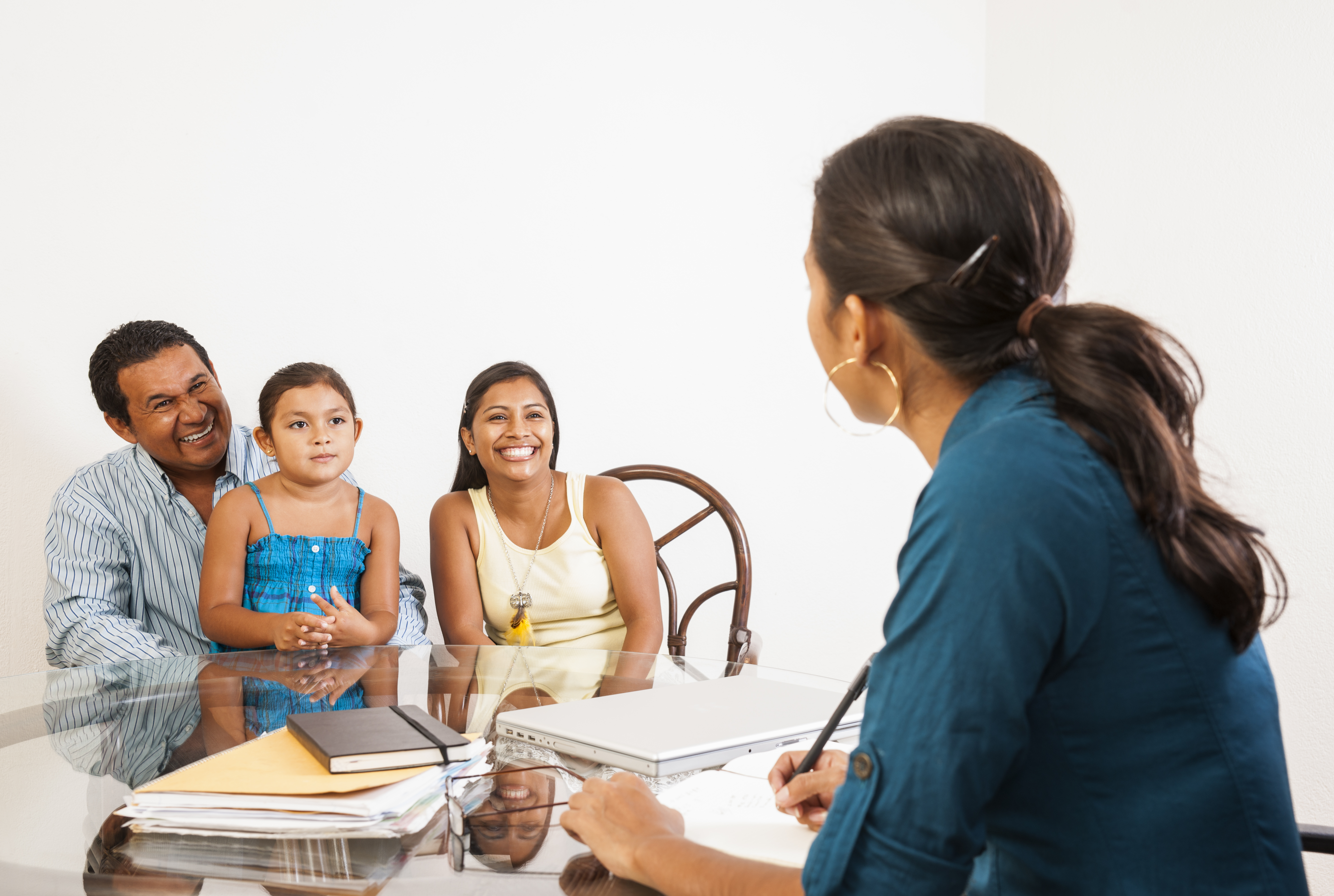Family sitting at table with social worker.