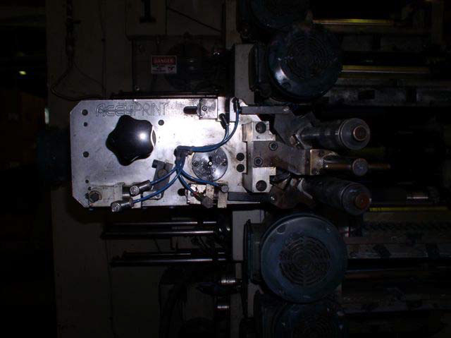 A black plastic knob juts out from a metal tray on the side of a machine. The knob has grips for hand control.