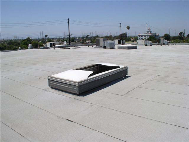A flat white rooftop surrounds a broken skylight that protrudes from the roof.