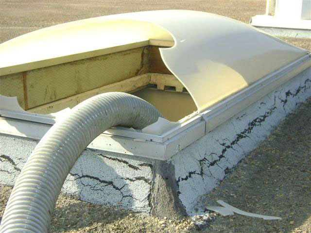 Close-up showing raised base of skylight that worker tripped through and cracked hole that he fell through.