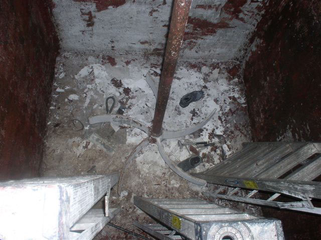 A full view of the inside of the tank shows both shoes of the recovered worker and the three upright, five-rung ladders used to descend into the tank.
