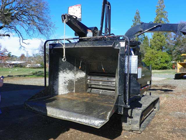The wood chipper feed table and feed rollers.