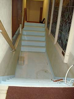 The narrow stairs and floor area of the baptismal font