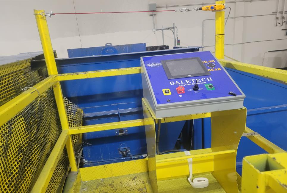 Yellow barrier around the control panel, the hopper, safety barrier and red cable. 