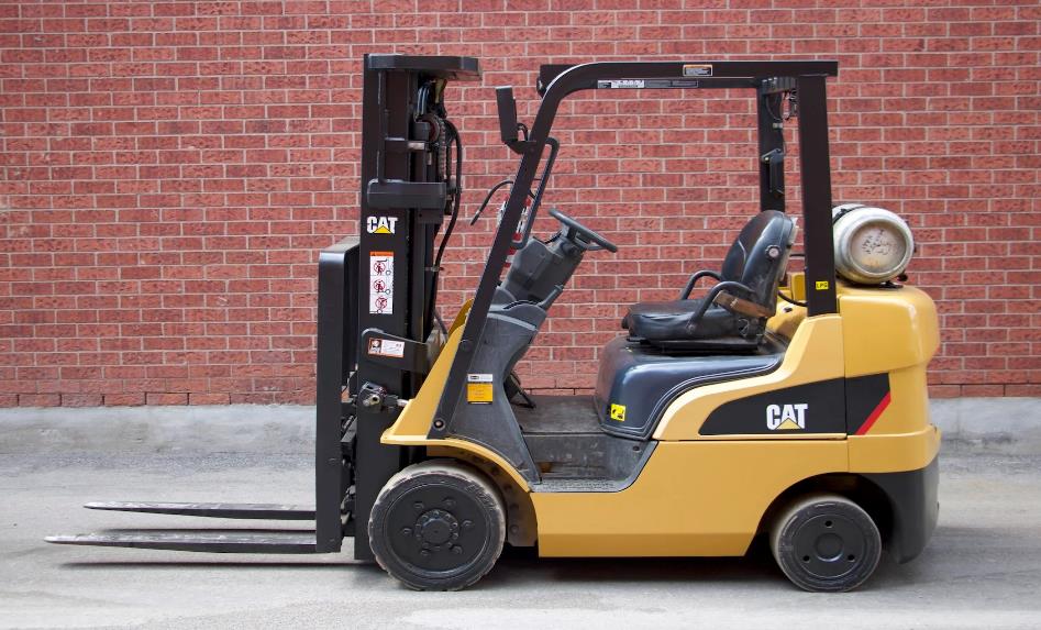 A CAT model 2C6000 forklift outside a building
