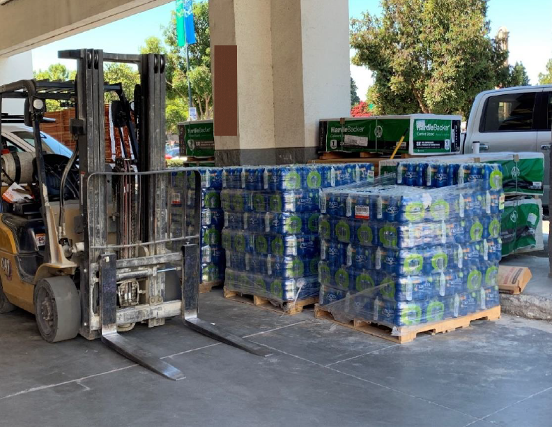 Outdoor loading area at the front of the building , and large quantities of pallets. 