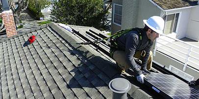 Solar panel worker on a household roof Solar panel worker on a household roof