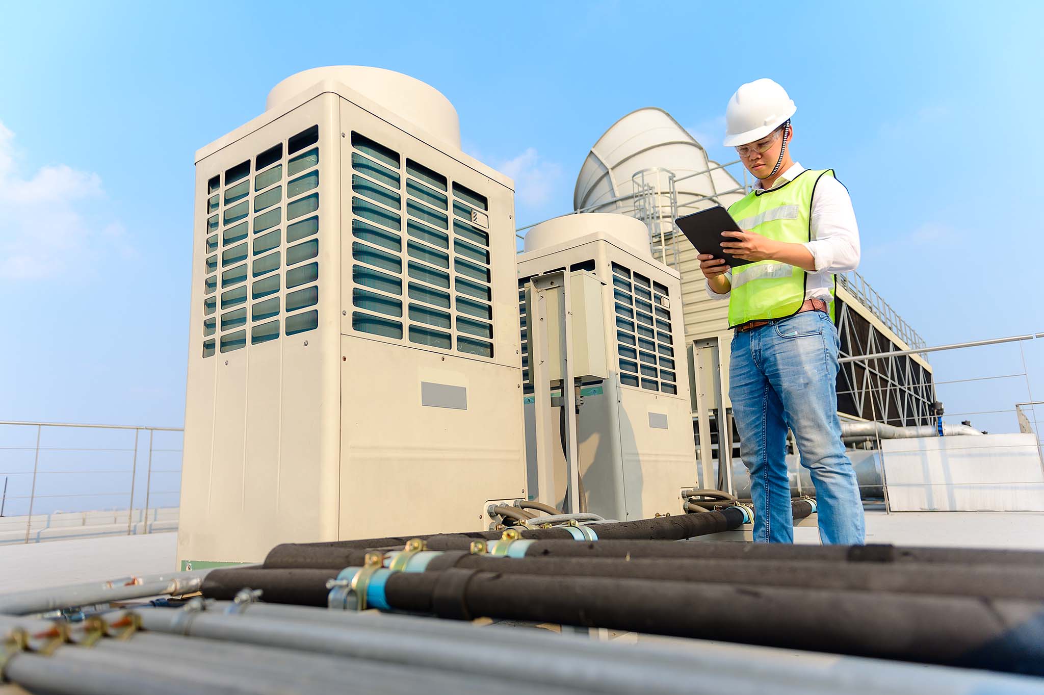 HVAC worker standing beside HVAC