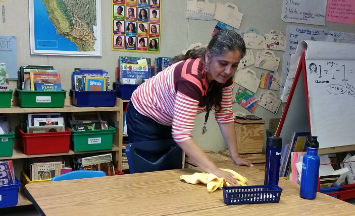 woman wiping desk