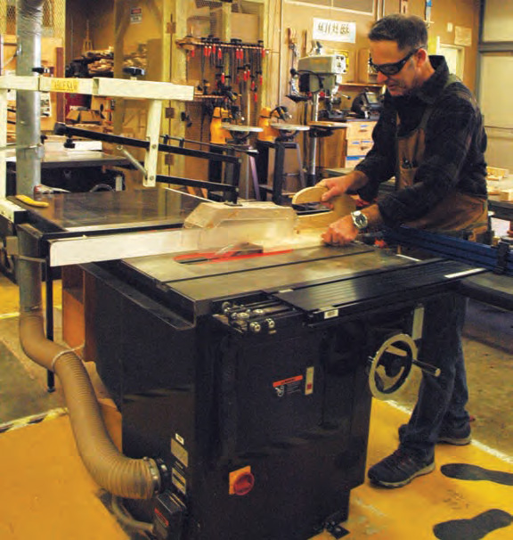 A worker uses a saw equipped with ventilation that captures dust
