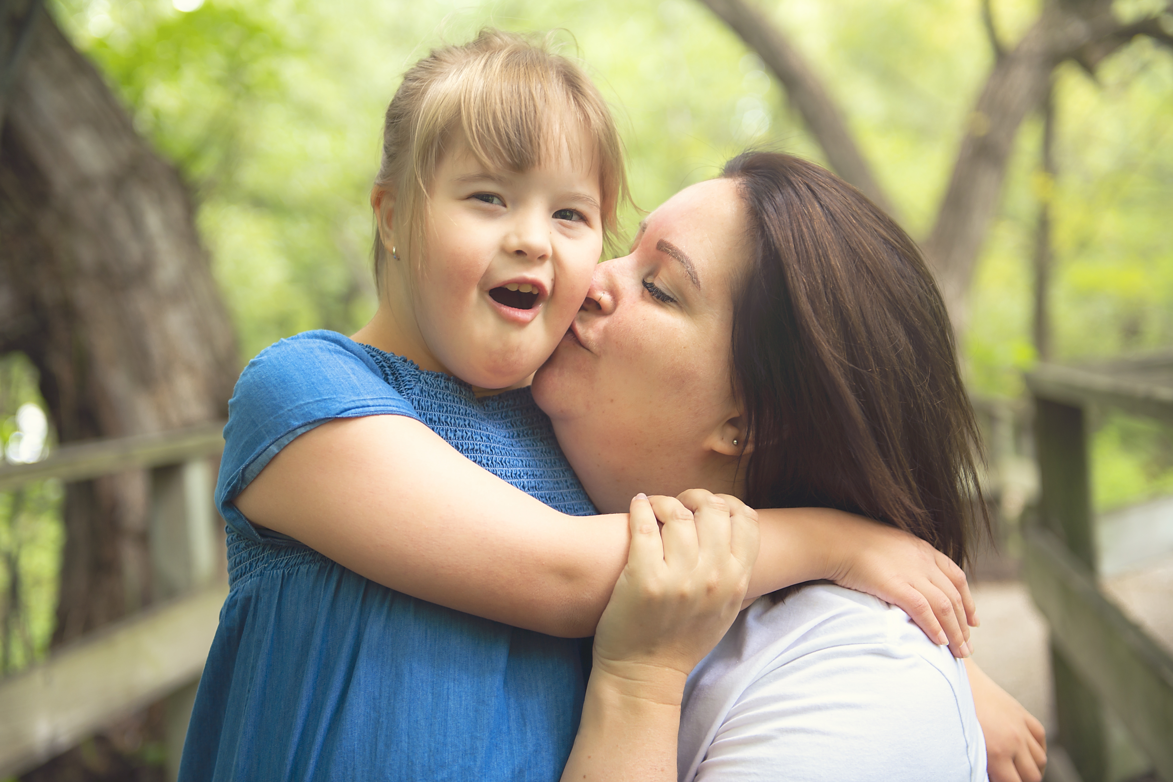 Mother kissing child with down syndrome Mother kissing child with down syndrome