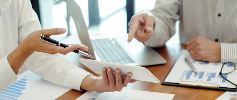 two people pointing to papers with data two people pointing to papers with data