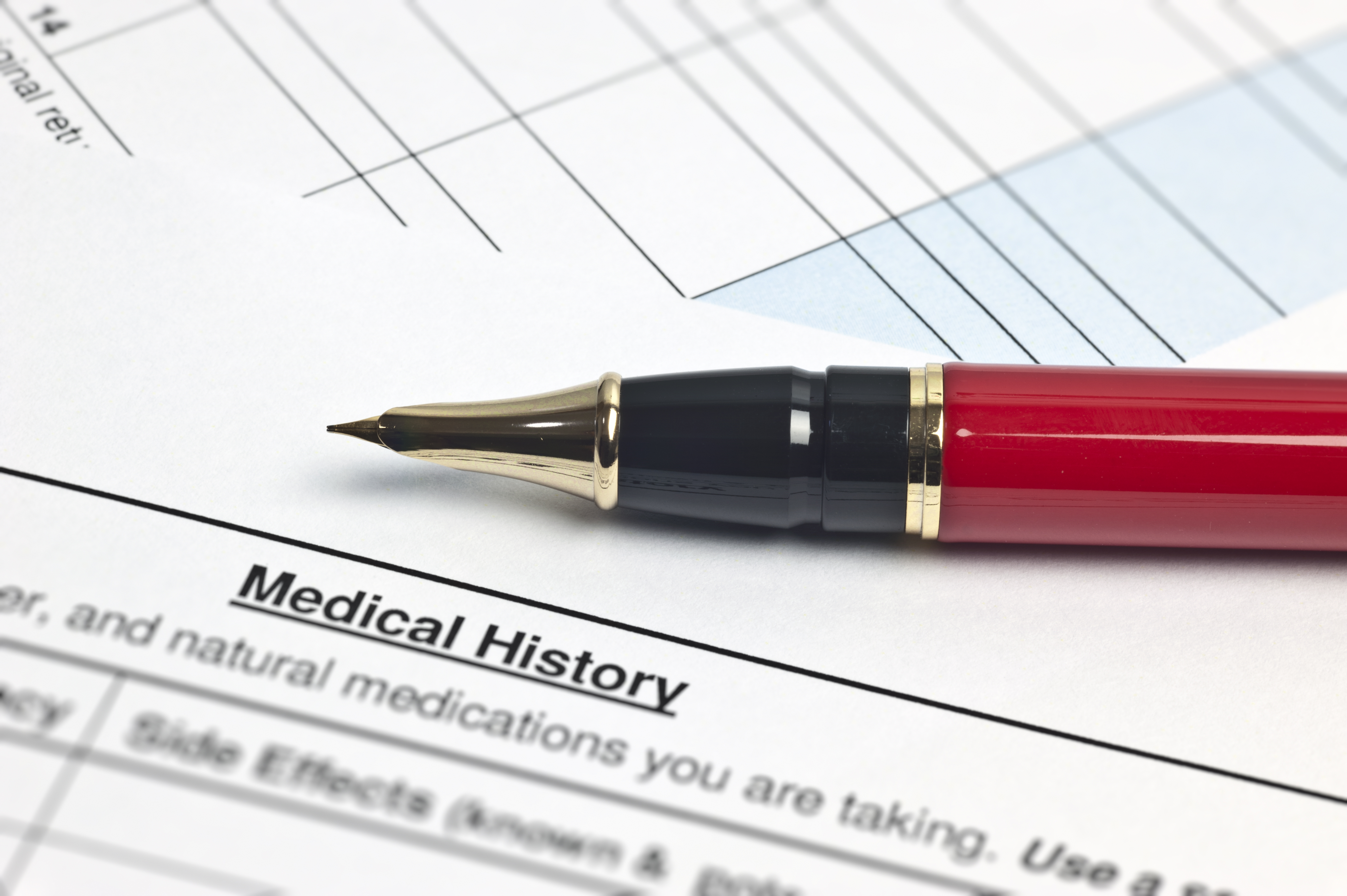 pen on top of a medical history paper pen on top of a medical history paper