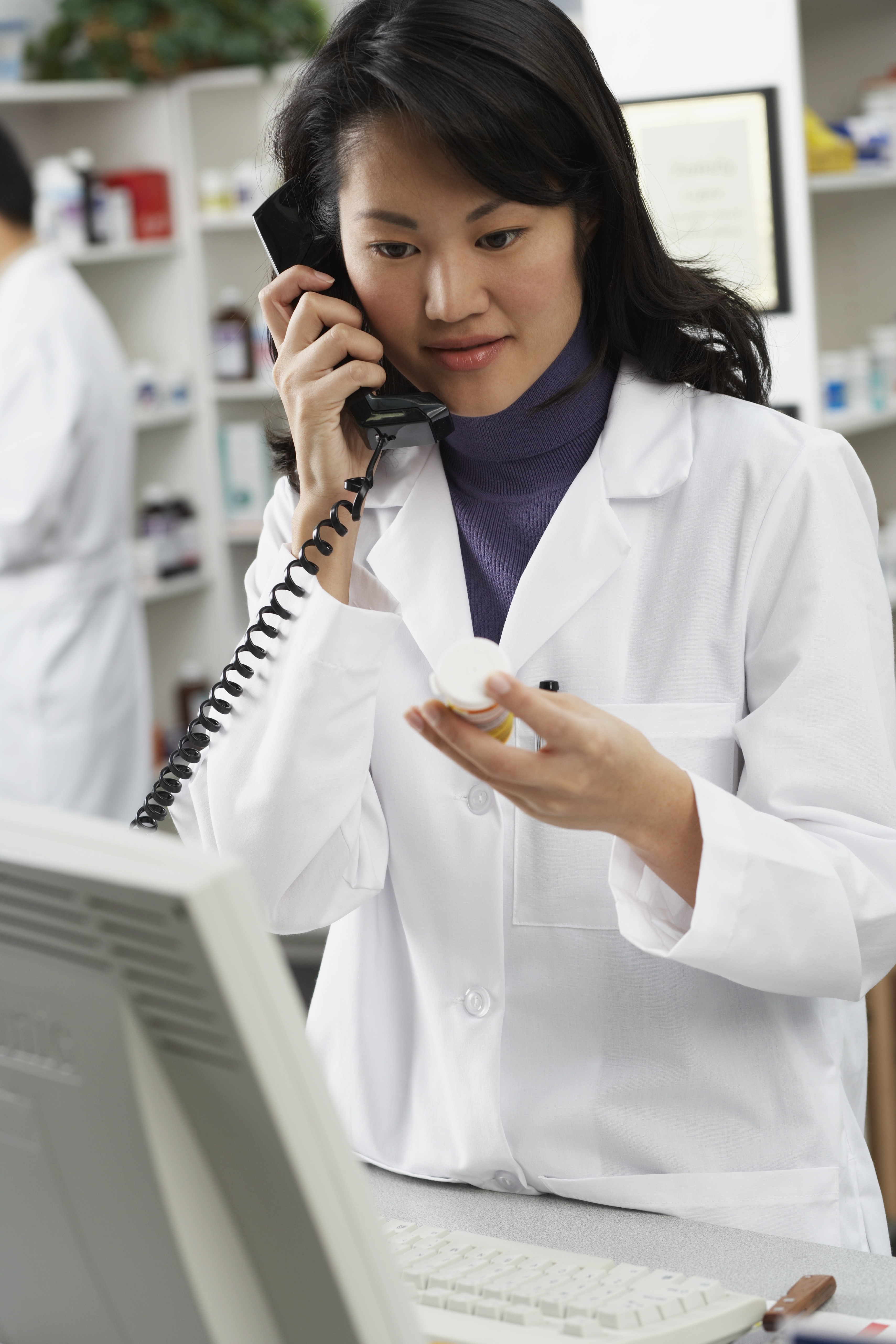 GettyImages-72003489_AsianFemalePharmHoldingMedBottleOnPhone
