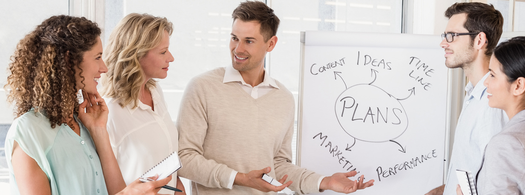 Employees gathered around a whiteboard
