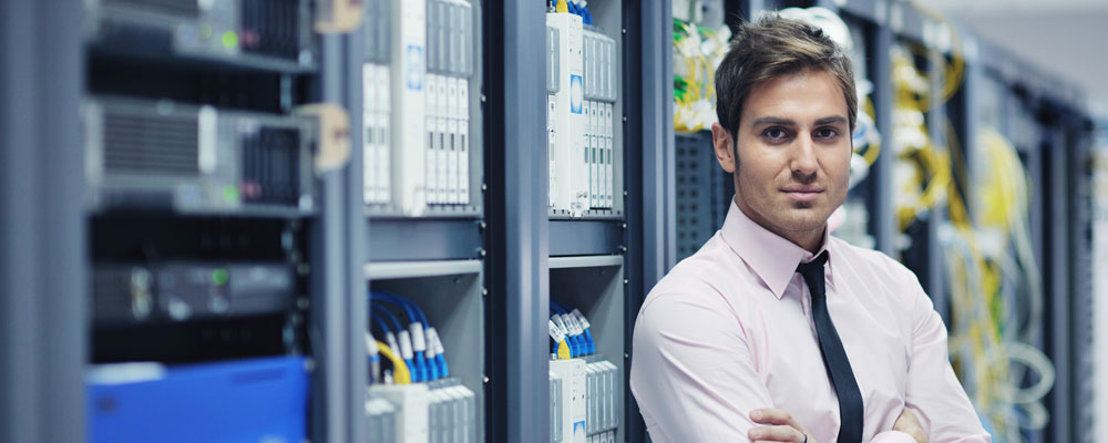 Employee standing in front of computer systems